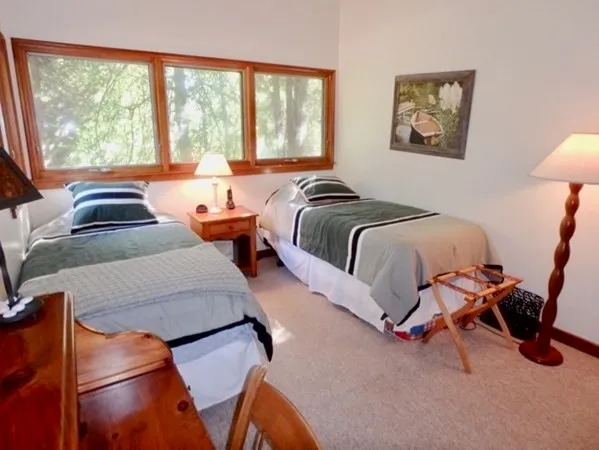 a bedroom with two beds and a large window