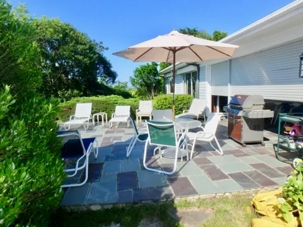 a view of a patio with table and chairs under an umbrella
