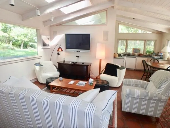 a bedroom with a bed wooden floor and flat screen tv
