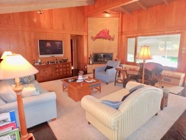 a living room with furniture a lamp and a large window