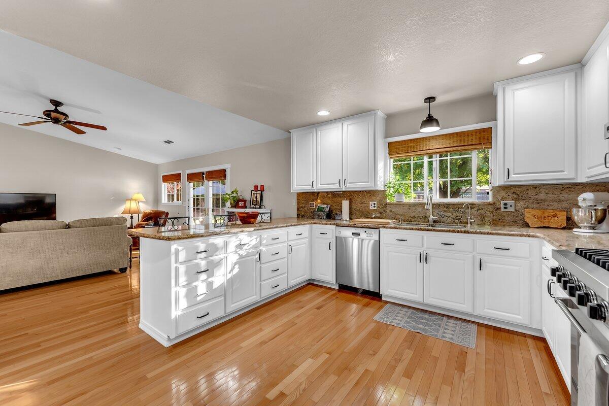12269 Dry Creek Road Bella Vista, CA 96008 - Photo 14 of 74 a kitchen with stainless steel appliances granite countertop a stove a sink and a granite counter tops with wooden floors