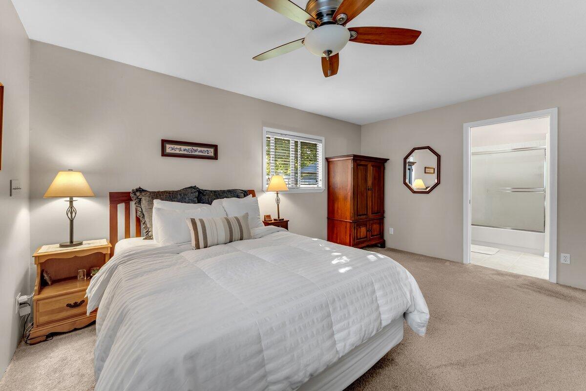 12269 Dry Creek Road Bella Vista, CA 96008 - Photo 21 of 74 a bedroom with a bed and a chandelier