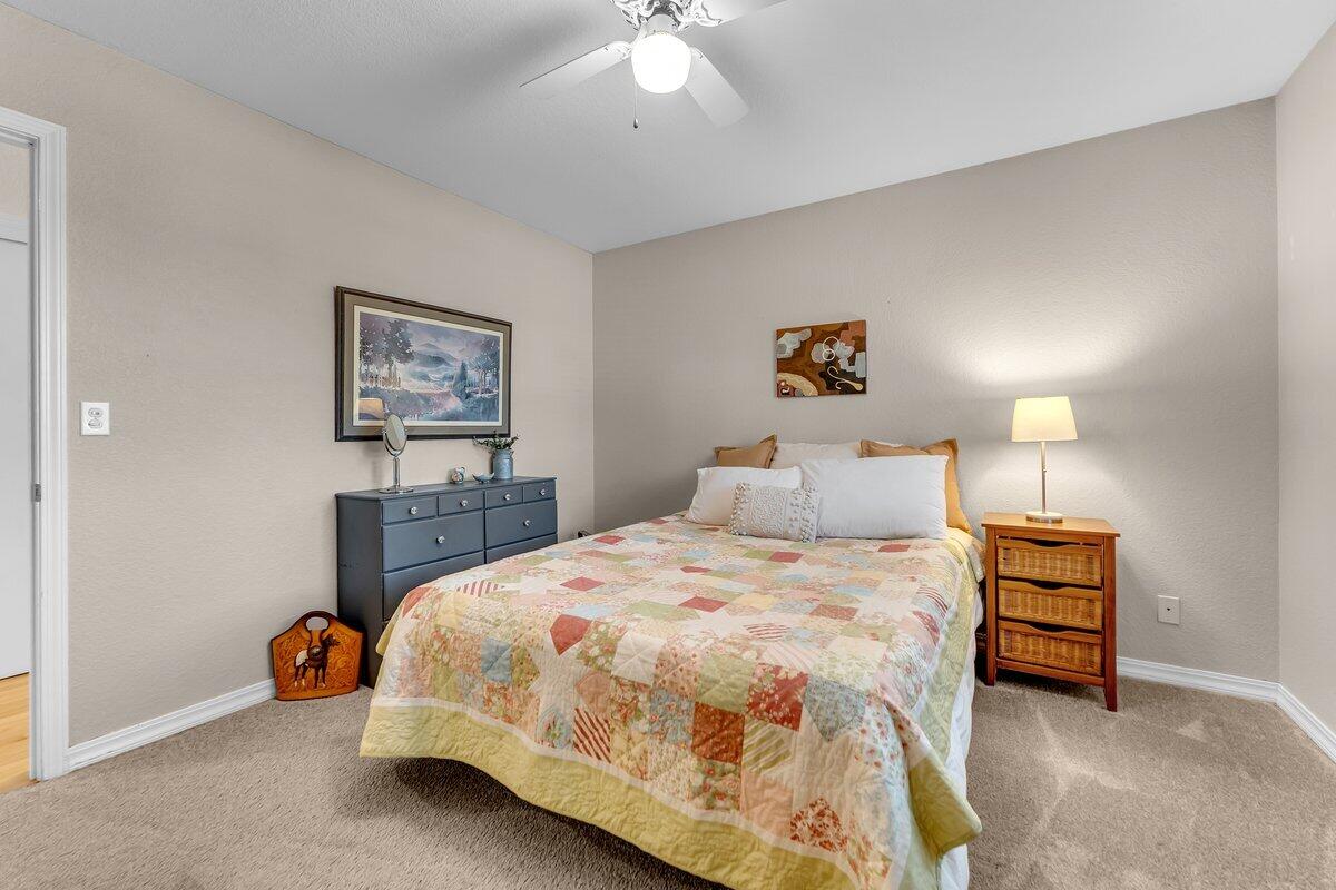 12269 Dry Creek Road Bella Vista, CA 96008 - Photo 24 of 74 a bedroom with a bed and a chandelier