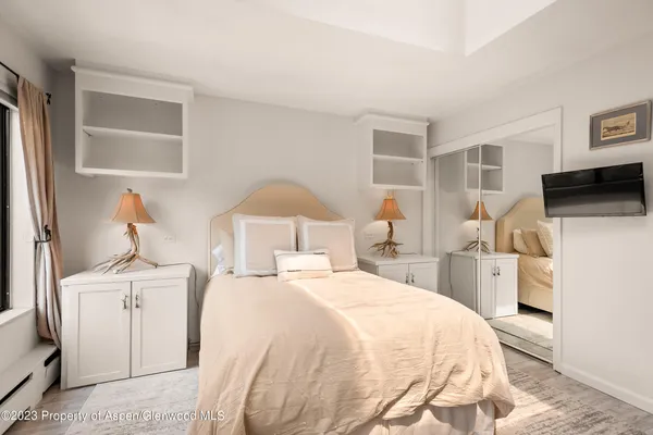 a large bed sitting in a bedroom and a lamp