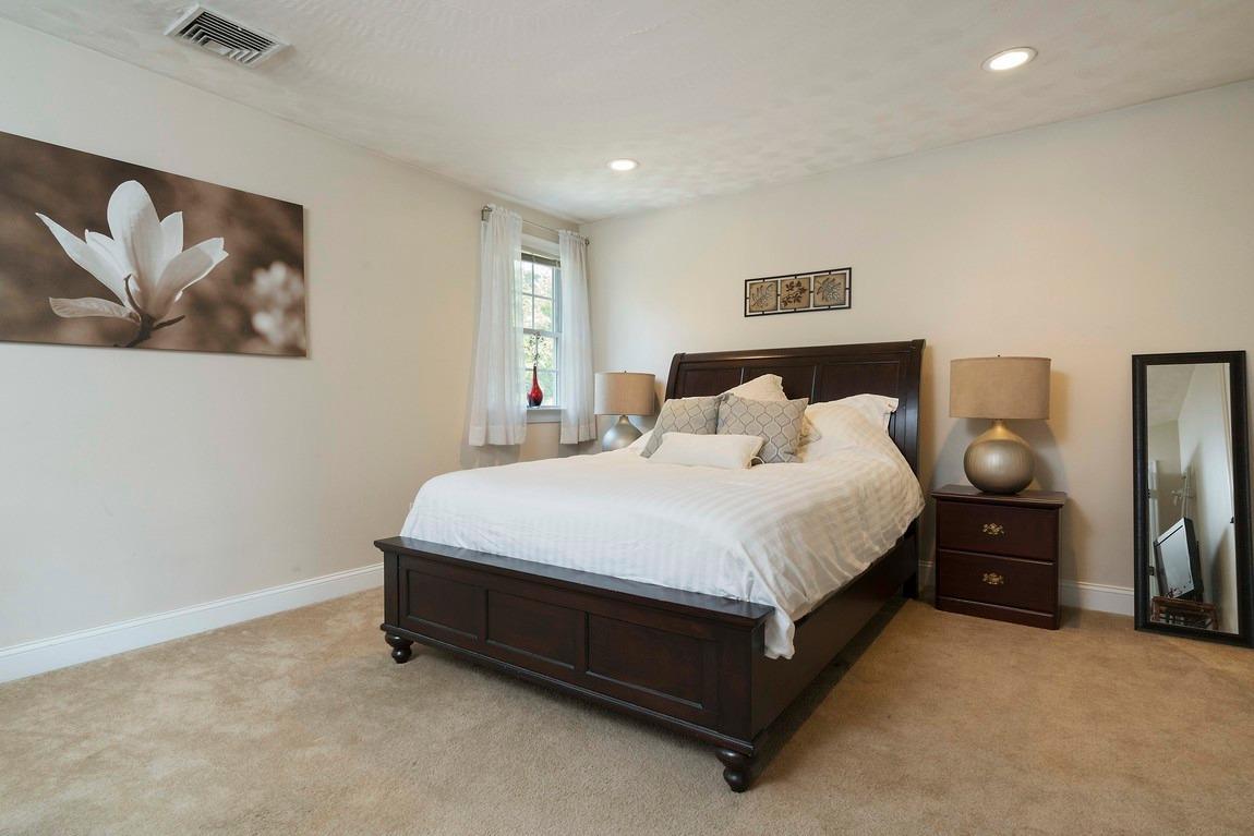89 Old Hyannis Road Yarmouth Port, MA 02675 - Photo 27 of 35 a spacious bedroom with a bed and painting on the wall