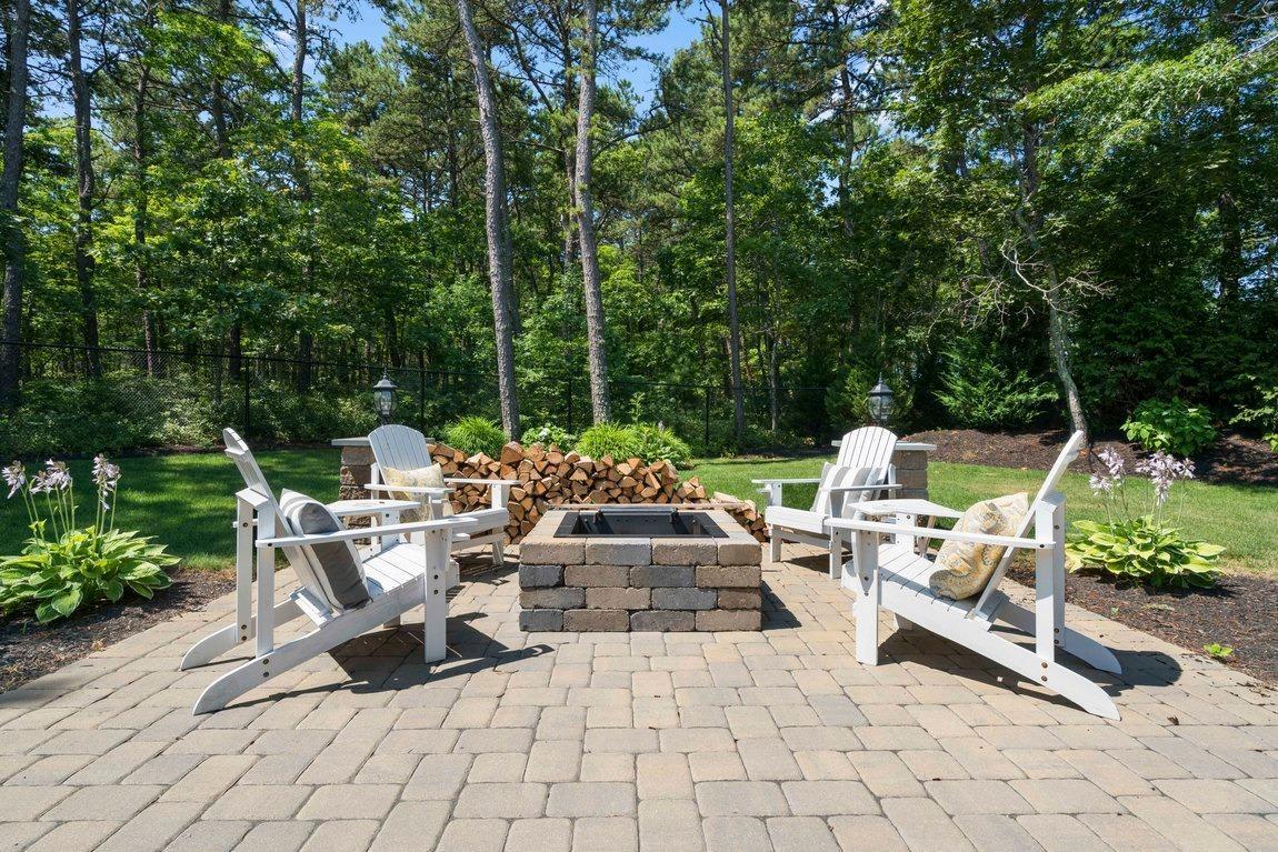 89 Old Hyannis Road Yarmouth Port, MA 02675 - Photo 30 of 35 a view of a patio with a dining table and chairs with wooden fence