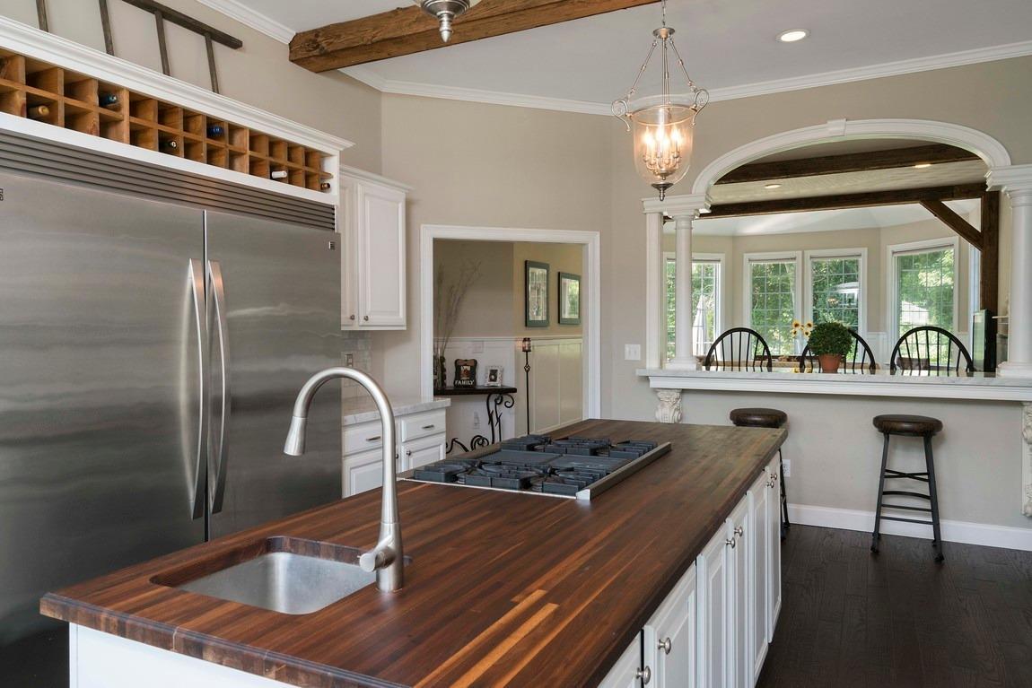 89 Old Hyannis Road Yarmouth Port, MA 02675 - Photo 9 of 35 a kitchen with kitchen island a counter top a stove a chimney a sink and dining table