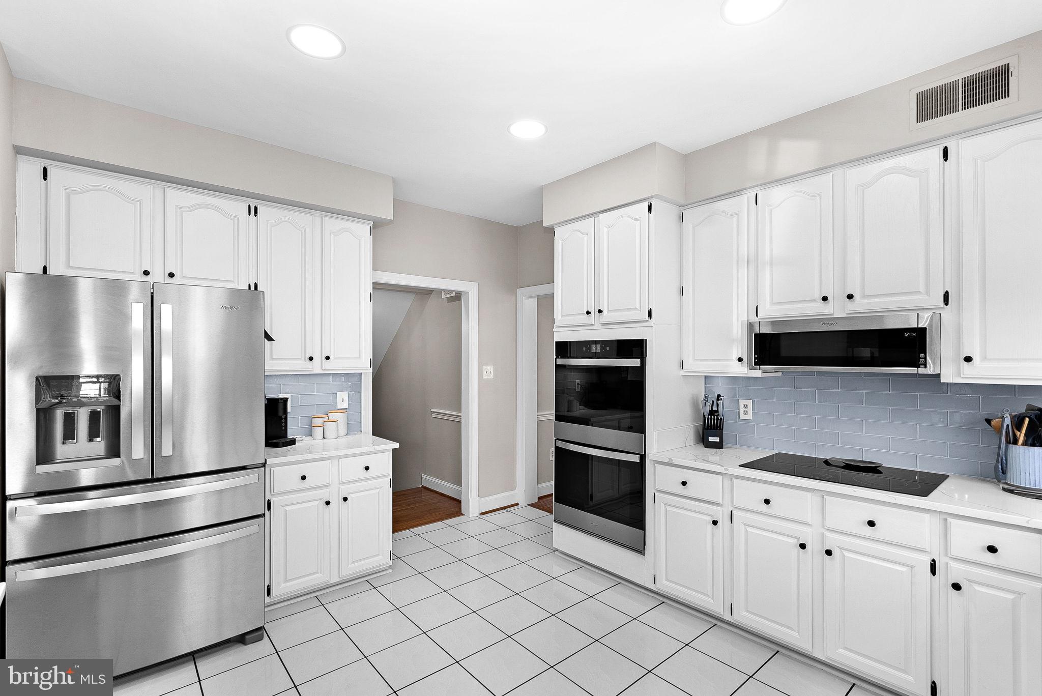 9440 Flowerden Lane Manassas, VA 20110 - Photo 15 of 66 a kitchen with stainless steel appliances and white cabinets