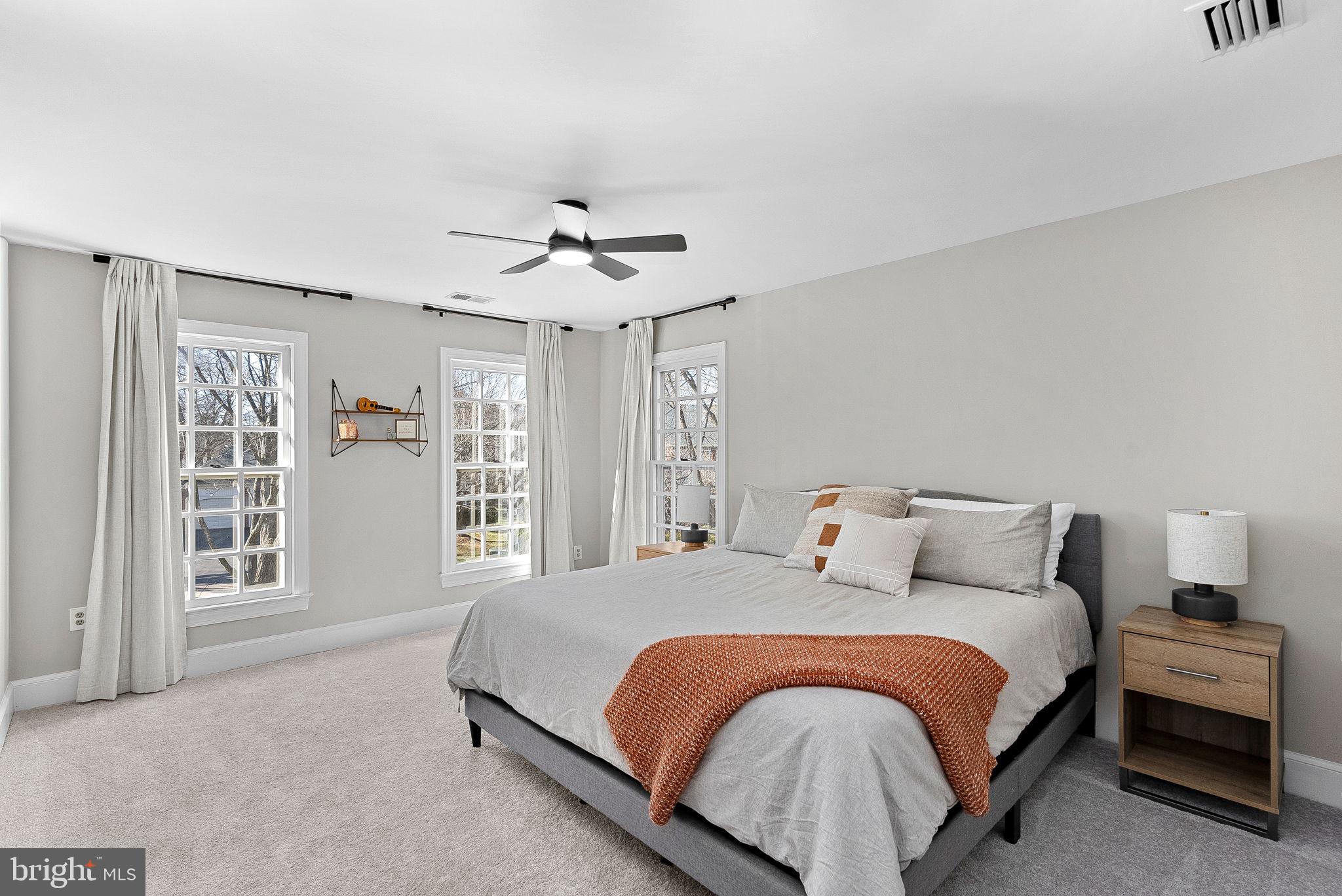 9440 Flowerden Lane Manassas, VA 20110 - Photo 40 of 66 a bedroom with a large bed and a chandelier