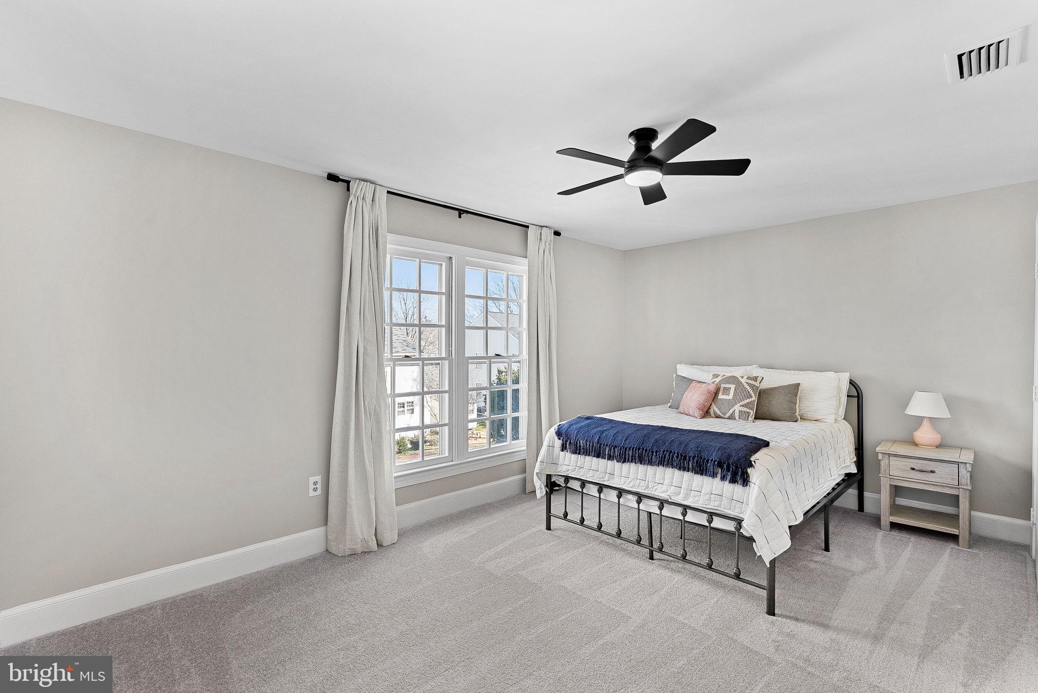 9440 Flowerden Lane Manassas, VA 20110 - Photo 43 of 66 a bedroom with a bed chandelier and a window