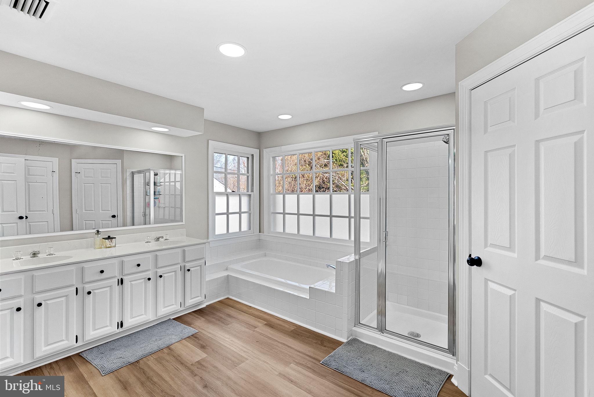 9440 Flowerden Lane Manassas, VA 20110 - Photo 45 of 66 a spacious bathroom with a double vanity sink a large mirror and shower
