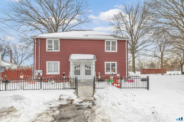 a front view of a house with a yard covered with snow