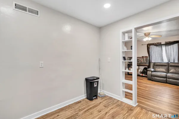 a view of a livingroom with wooden floor and furniture