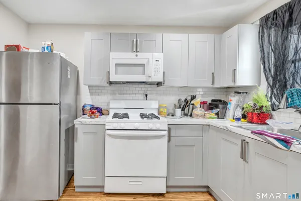 a kitchen with a sink a refrigerator and cabinets