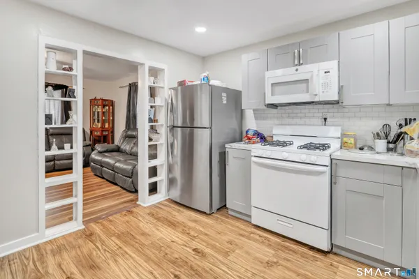 a kitchen with white cabinets and refrigerator