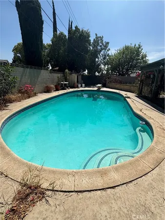 a view of a swimming pool and trees in the background
