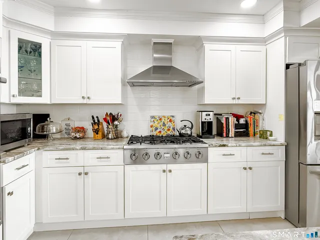 a kitchen with white cabinets and white appliances