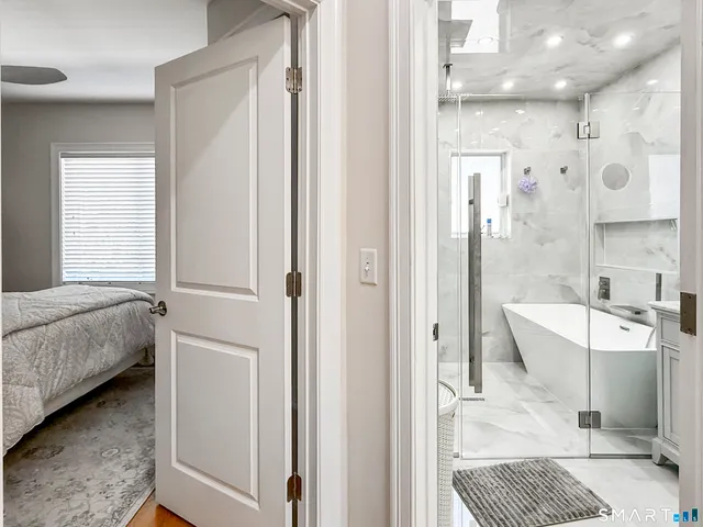 a bathroom with a bathtub shower sink and mirror