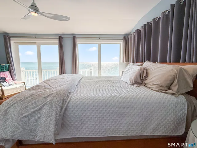 a large bed sitting in a bedroom next to a window