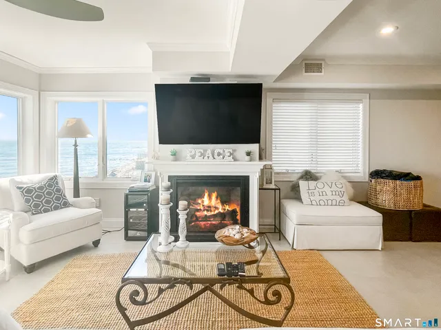 a living room with furniture a flat screen tv and a fireplace