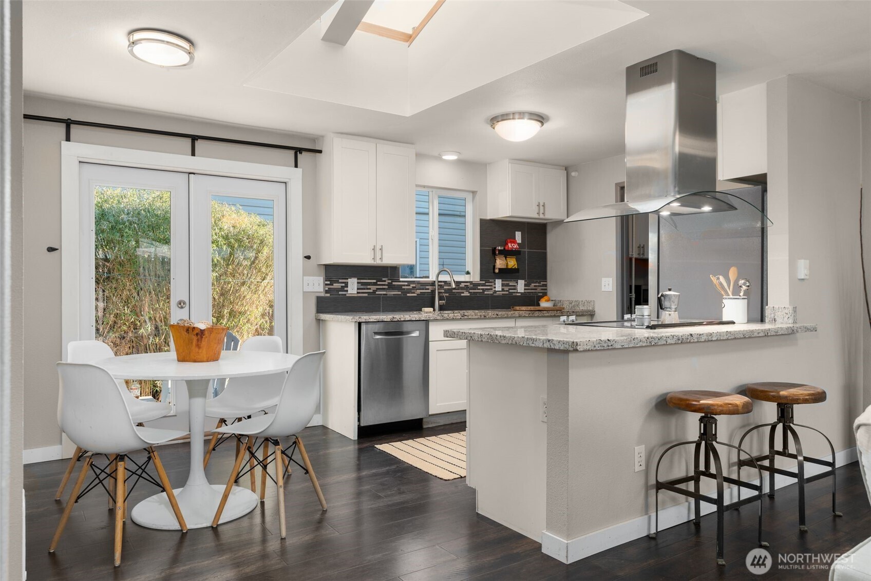 6528 23rd Avenue Southwest Seattle, WA 98106 - Photo 6 of 39 a kitchen with stainless steel appliances kitchen island granite countertop a stove a refrigerator a kitchen island with a dining table and chairs