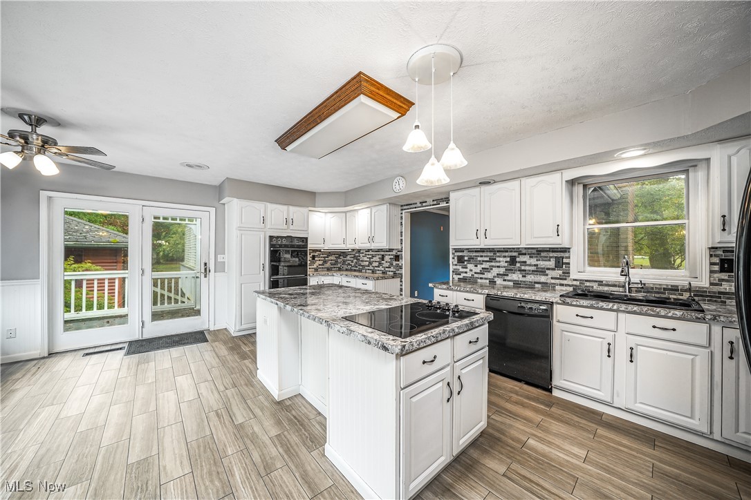 2822 Selkirk Bush Road Warren, OH 44481 - Photo 6 of 50 Kitchen with a kitchen island, white cabinetry, healthy amount of natural light, hanging light fixtures, and a textured ceiling
