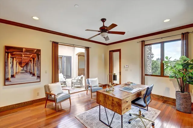 a living room with a dining table and paintings on the wall with wooden floor