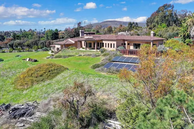 a view of a house with pool and a yard
