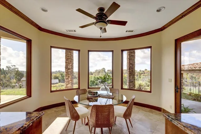 a dining room with furniture a chandelier and a large window