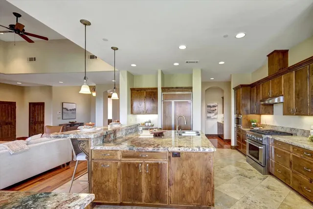 a kitchen with stainless steel appliances kitchen island granite countertop a sink and cabinets
