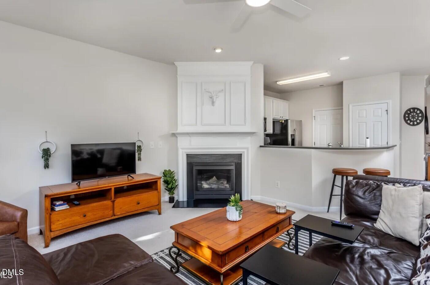 7031 Racine Way Raleigh, NC 27615 - Photo 10 of 24 a living room with furniture a flat screen tv and a fireplace