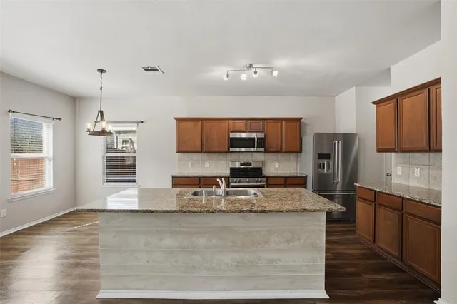 a kitchen with stainless steel appliances granite countertop a stove and wooden floor