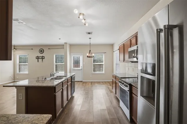 a large kitchen with granite countertop a large counter top appliances and cabinets