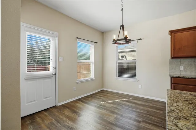 a kitchen with stainless steel appliances granite countertop a sink a stove and a wooden floors