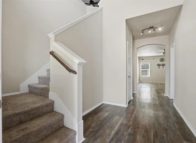 a view of a hallway view with wooden floor and staircase