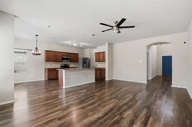 a view of kitchen with microwave refrigerator and cabinets