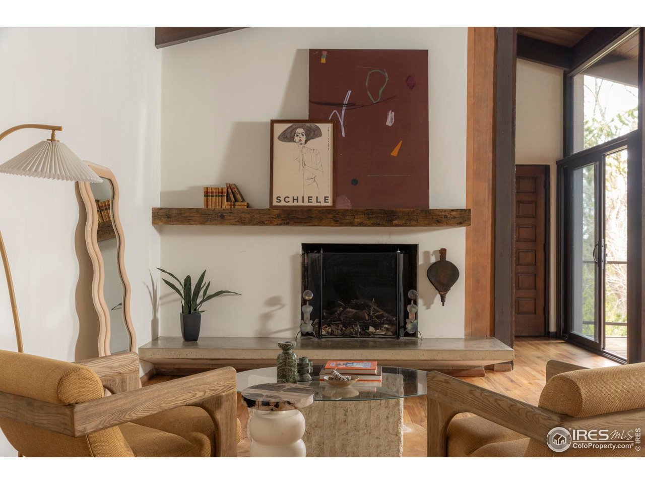 705 Willowbrook Road Boulder, CO 80302 - Photo 16 of 34 The spacious living room features beamed ceilings, floor-to-ceiling windows, and another wood-burning fireplace.