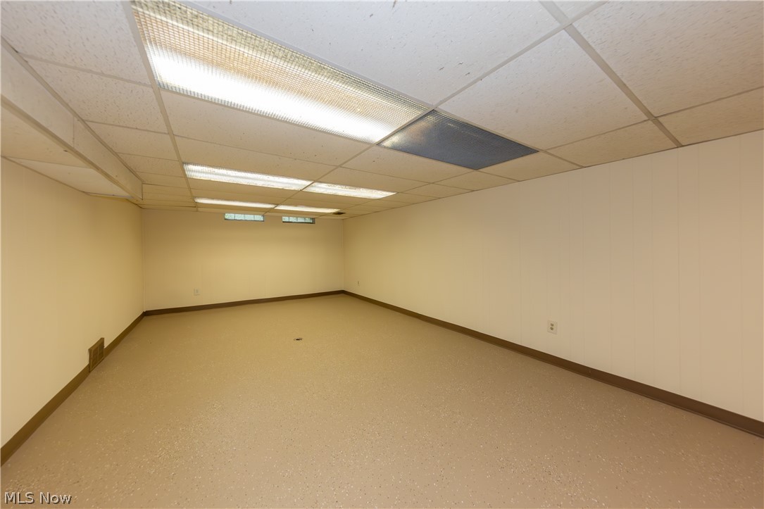 25001 Letchworth Road Beachwood, OH 44122 - Photo 39 of 50 Spacious room featuring a drop ceiling with fluorescent lighting, light-toned walls, and resilient flooring