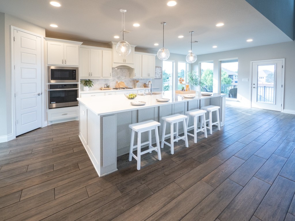 2001 Limestone Lake Drive Georgetown, TX 78633 - Photo 13 of 40 a large kitchen with cabinets wooden floor and stainless steel appliances