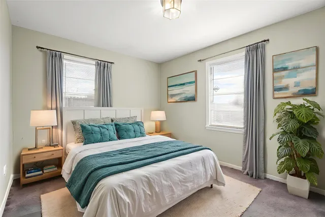 a bedroom with a bed and windows