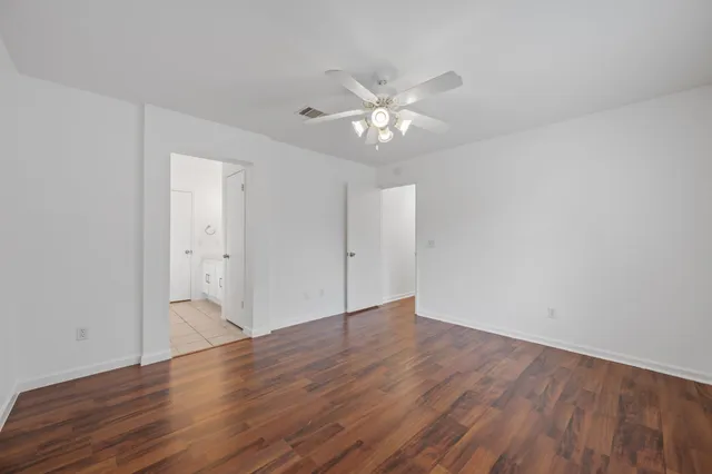 a view of an empty room with wooden floor