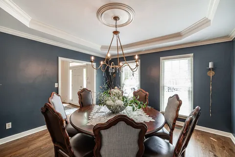 a dining room with furniture a chandelier and wooden floor