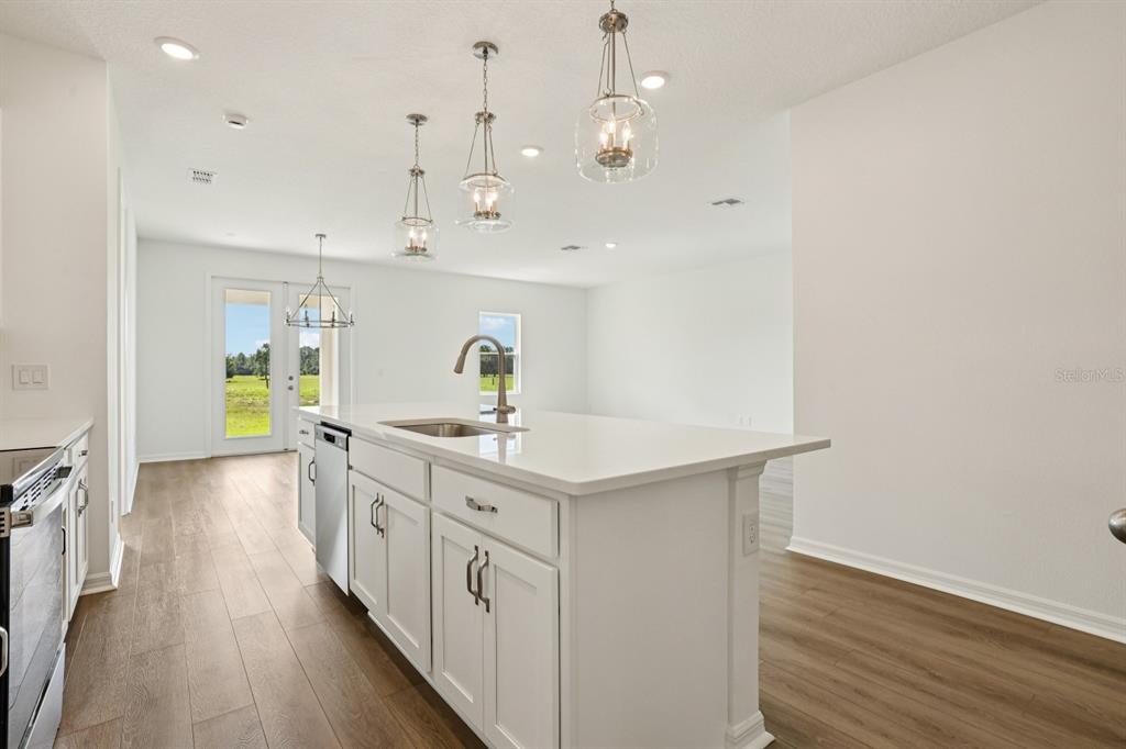 5740 Haystack Drive St. Cloud, FL 34771 - Photo 13 of 39 a kitchen with kitchen island a sink and a stove top oven