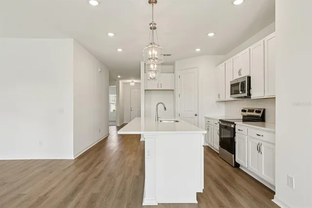 a large kitchen with kitchen island a sink stainless steel appliances and cabinets