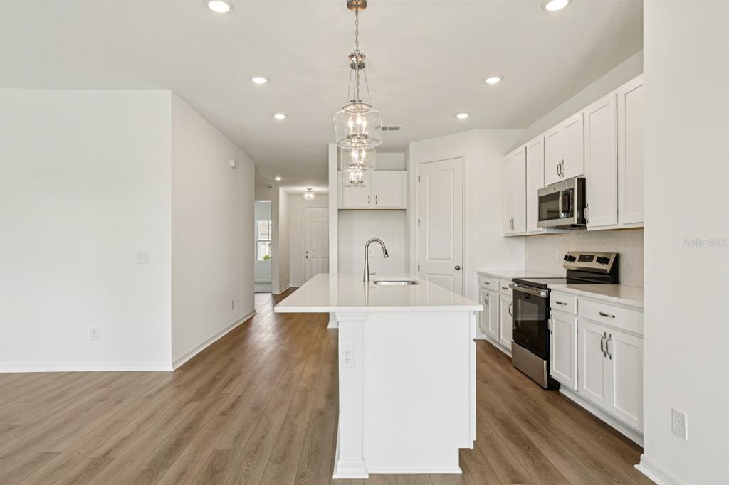 5740 Haystack Drive St. Cloud, FL 34771 - Photo 14 of 39 a large kitchen with kitchen island a sink stainless steel appliances and cabinets