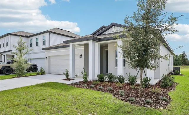 a front view of a house with a yard and potted plants