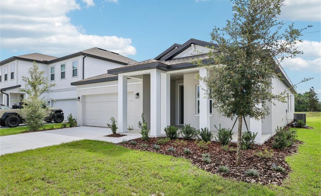 5740 Haystack Drive St. Cloud, FL 34771 - Photo 3 of 39 a front view of a house with a yard and potted plants