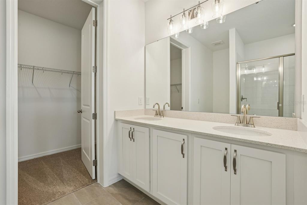 5740 Haystack Drive St. Cloud, FL 34771 - Photo 31 of 39 a bathroom with a double vanity sink and mirror