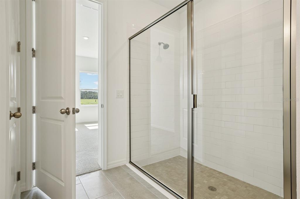 5740 Haystack Drive St. Cloud, FL 34771 - Photo 32 of 39 a bathroom with a glass shower door