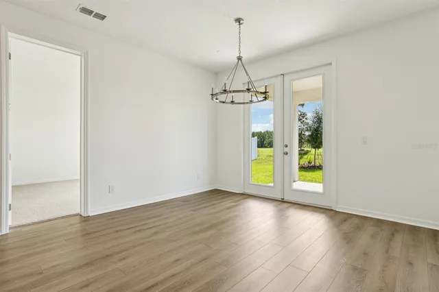 a view of empty room with wooden floor and sink